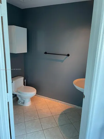 a white toilet sitting next to a bathroom sink