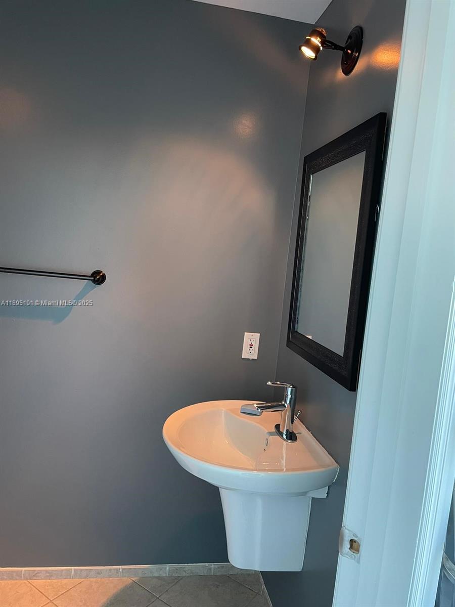 60 Southwest 13th Street, Unit 3426 Miami, FL 33130 - Photo 15 of 32 a bathroom with a sink and mirror
