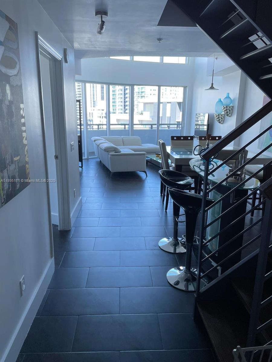 60 Southwest 13th Street, Unit 3426 Miami, FL 33130 - Photo 2 of 32 a room with lots of wooden furniture and glass windows