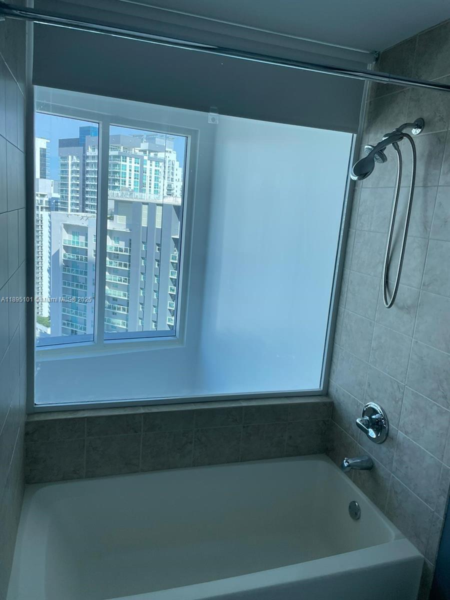 60 Southwest 13th Street, Unit 3426 Miami, FL 33130 - Photo 21 of 32 a bathroom with a bathtub and a shower