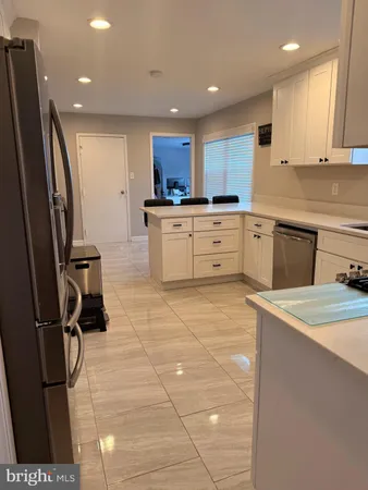 a large kitchen with stainless steel appliances granite countertop a stove a sink dishwasher and a refrigerator