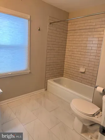 a bathroom with a toilet and a bath tub