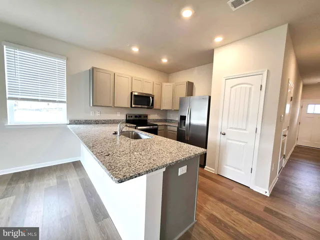 a kitchen with kitchen island a counter top space cabinets and appliances