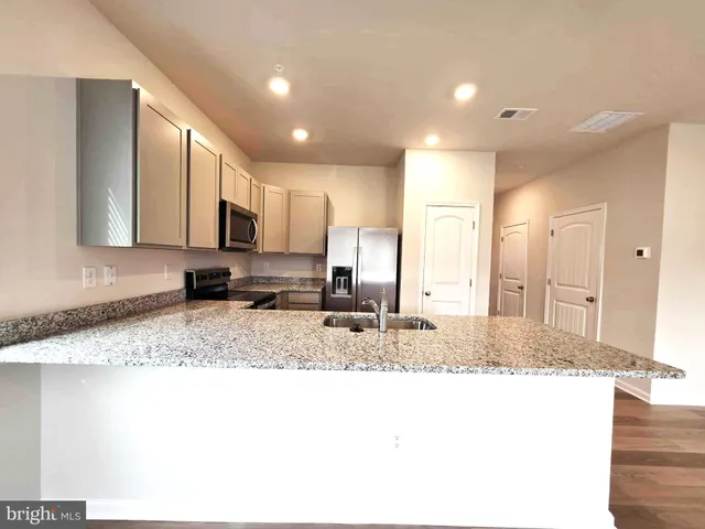 a kitchen with a refrigerator sink and cabinets