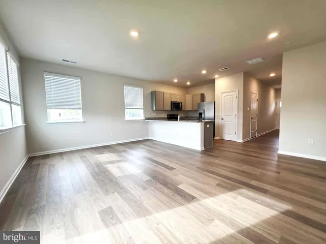 a view of kitchen with kitchen island microwave and view living room