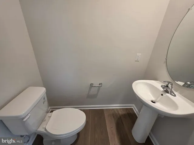 a bathroom with a toilet a sink and mirror