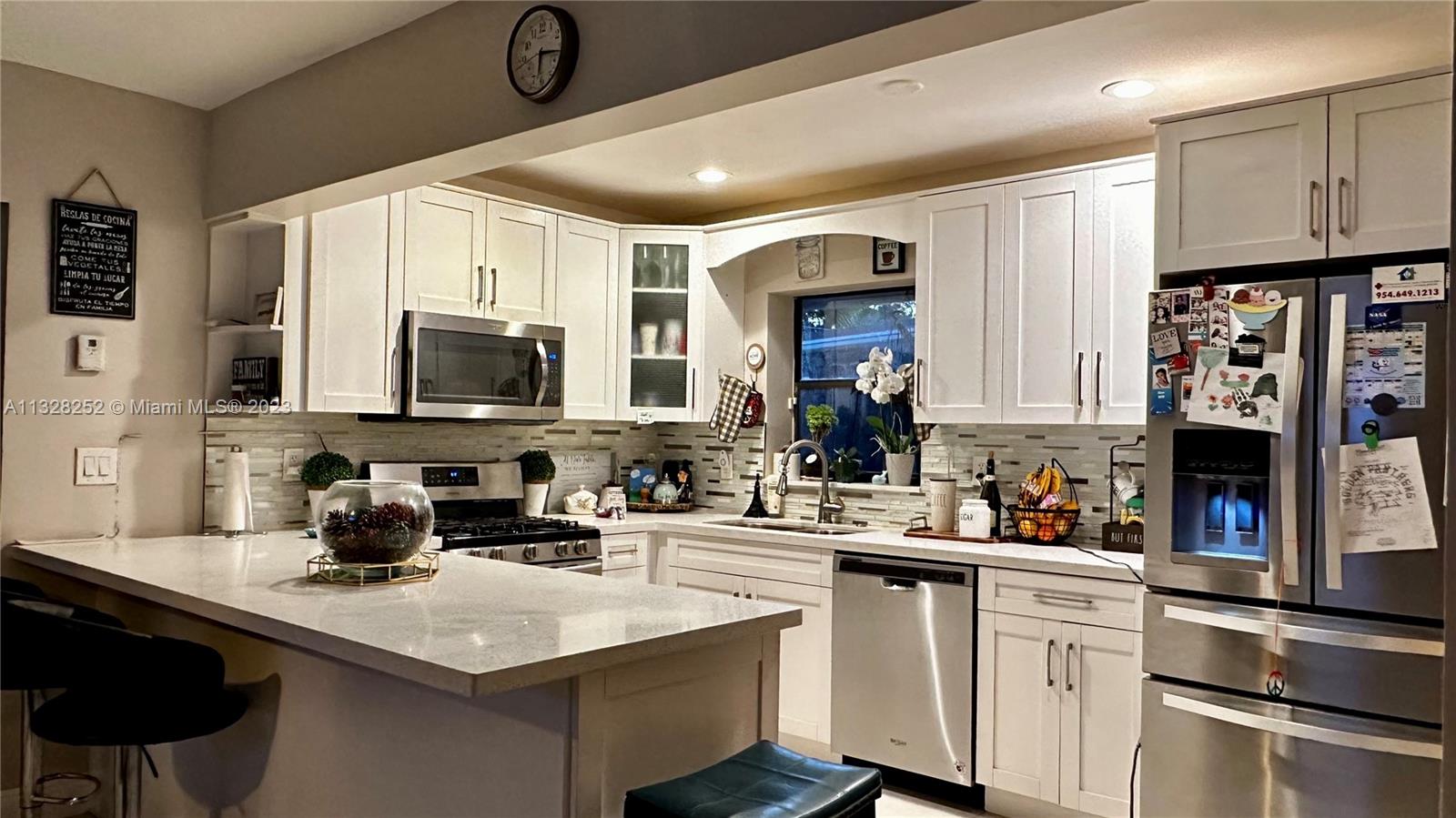 7810 Raleigh Street Hollywood, FL 33024 - Photo 8 of 16 a kitchen with stainless steel appliances granite countertop a sink a stove and cabinets