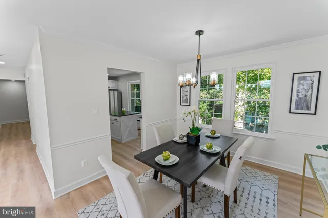 a view of a dining room with furniture a chandelier and wooden floor