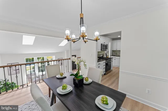 a kitchen with stainless steel appliances granite countertop a refrigerator a stove a sink dishwasher and white cabinets with wooden floor