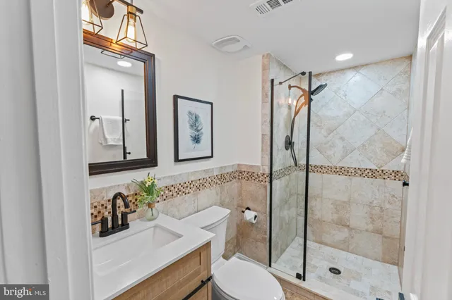 a bathroom with a bathtub shower sink mirror and toilet