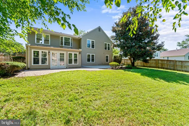 a view of a house with a big yard plants and large trees