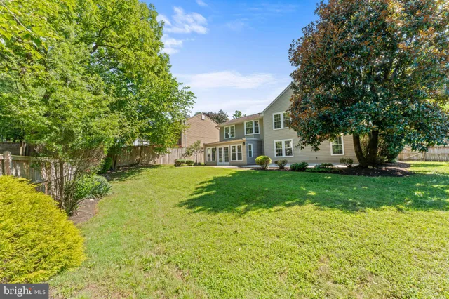 a view of a house with backyard and trees