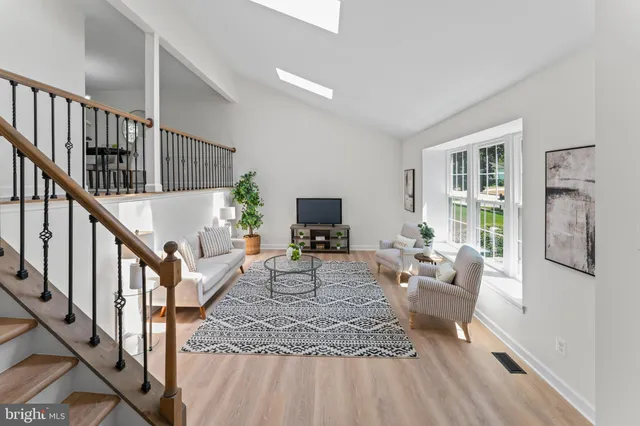 a living room with furniture a window and a flat screen tv
