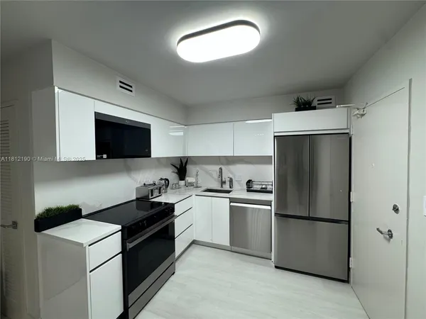 a kitchen with a refrigerator sink and stove top oven