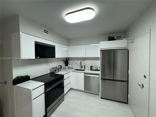 a kitchen with a refrigerator sink and stove top oven