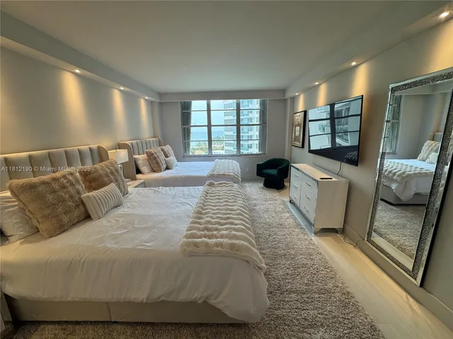 a large bed sitting in a bedroom next to a window