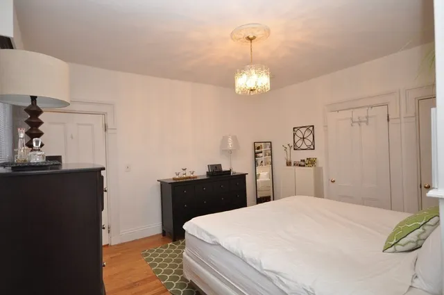 a bedroom with a bed and a chandelier