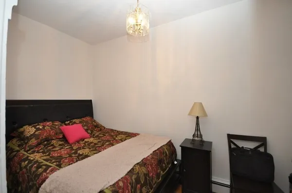 a bed sitting in a bedroom next to a lamp