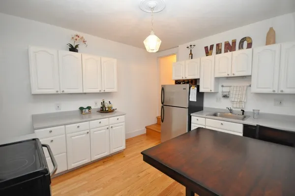 a kitchen with white cabinets and stainless steel appliances