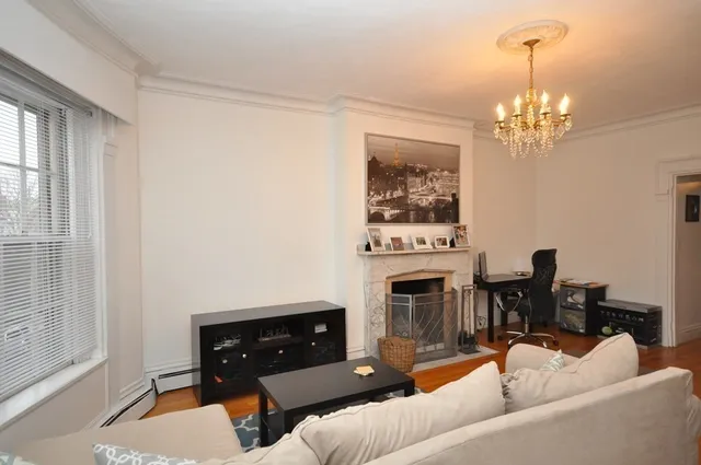 a living room with furniture a fireplace and a window
