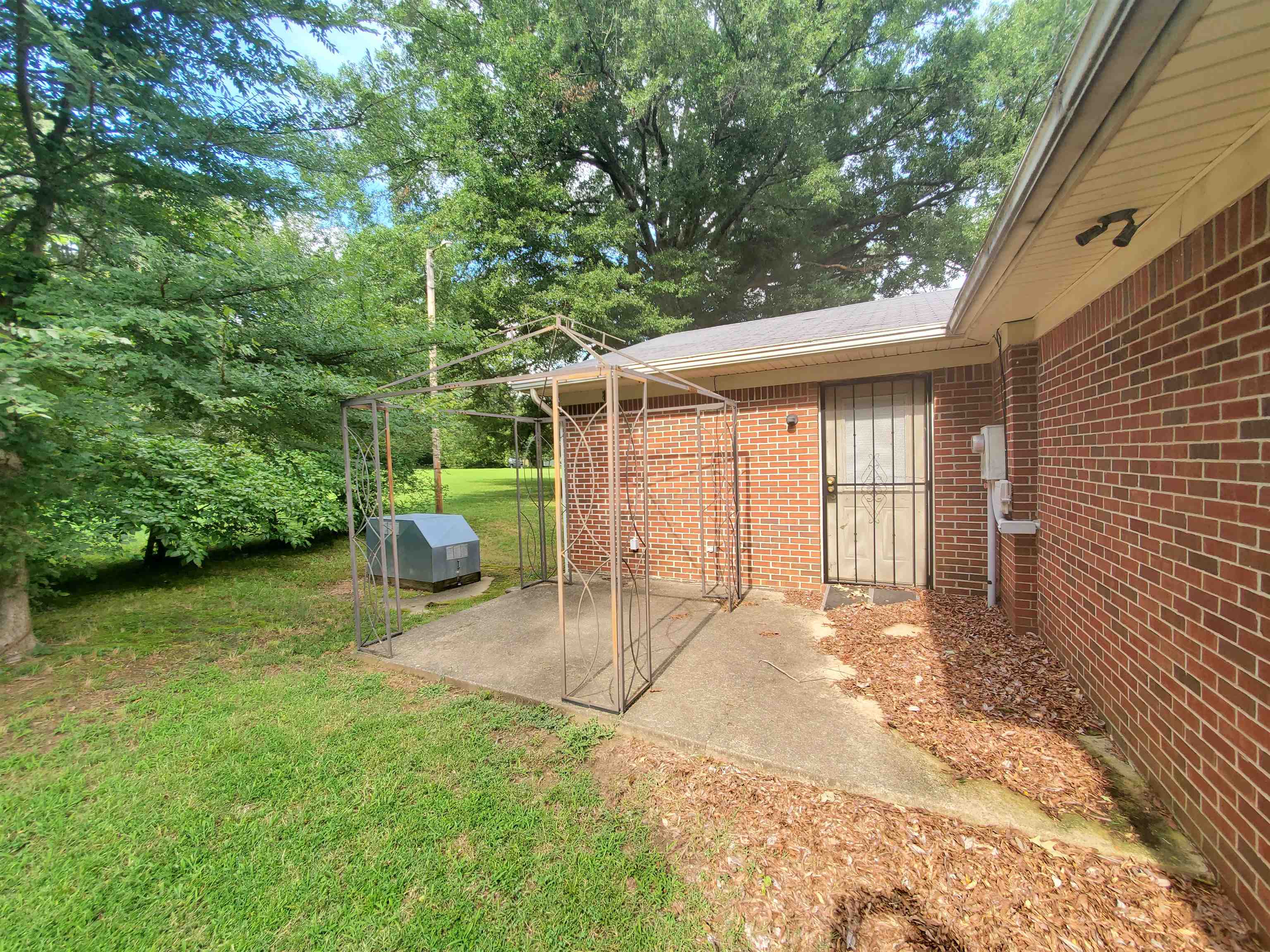 147 Rogers Street Sharon, TN 38255 - Photo 3 of 16 Brick exterior featuring a private patio area with a metal gazebo frame