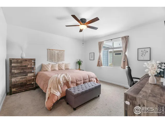 a bed room with a bed and a ceiling fan