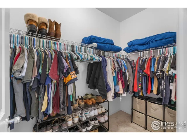 a view of walk in closet with clothes and shoes