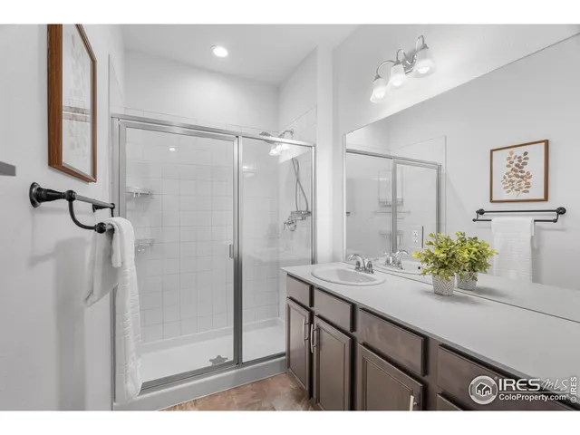 a bathroom with a shower sink vanity and mirror