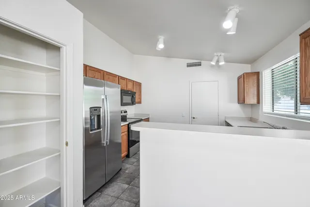a large white kitchen with a refrigerator a stove a sink and a cabinets