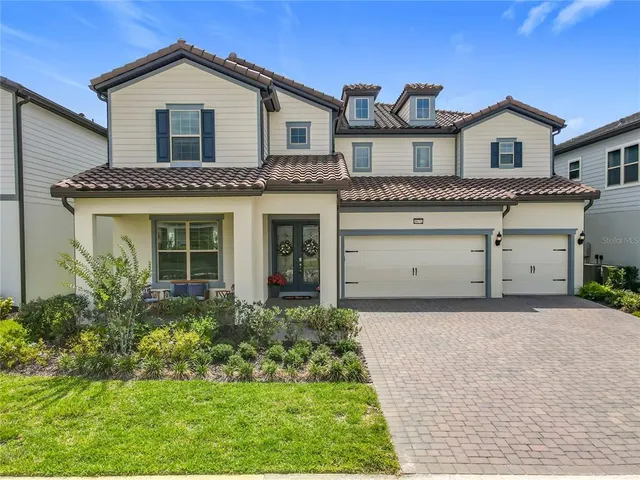 a front view of a house with a garden and garage