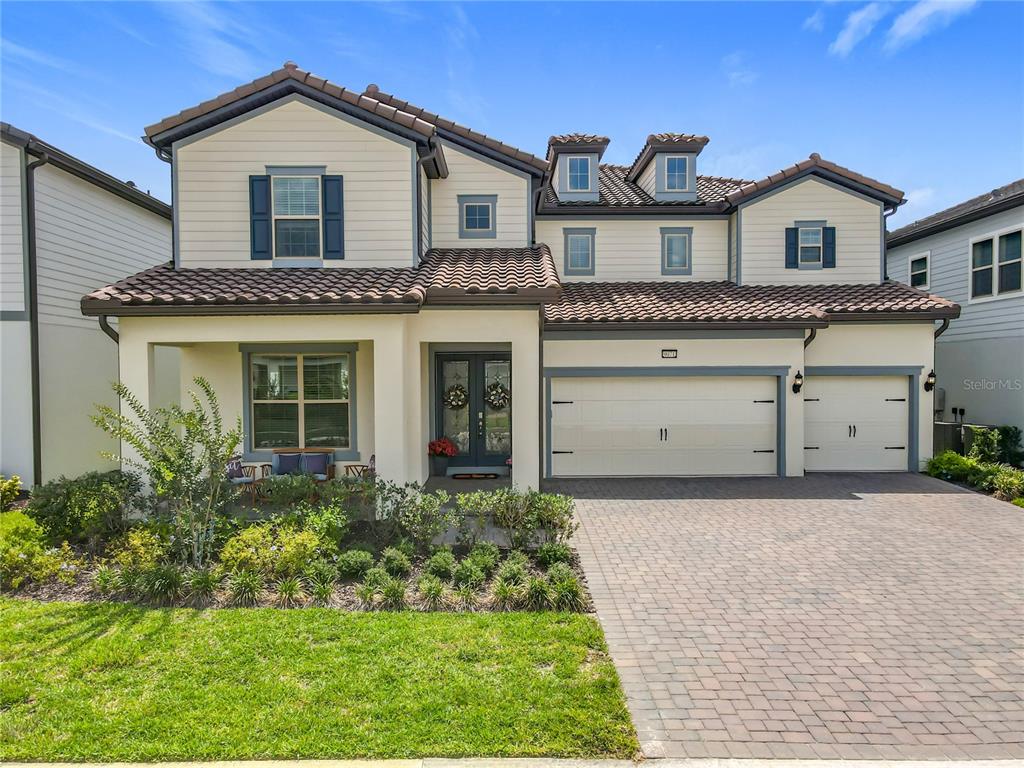 a front view of a house with a garden and garage