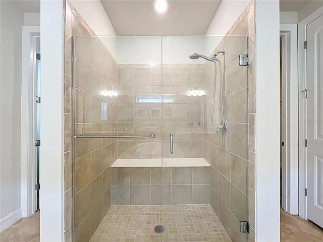 a spacious bedroom with a bed and a chandelier