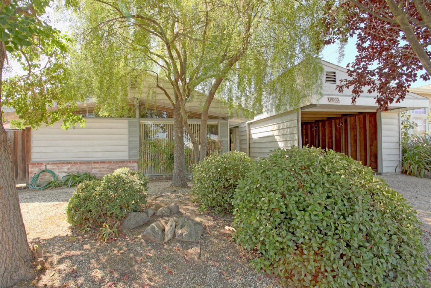 a view of a house with a large tree and plants