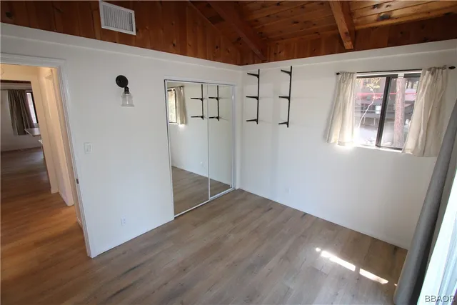 a view of a big room with wooden floor and windows