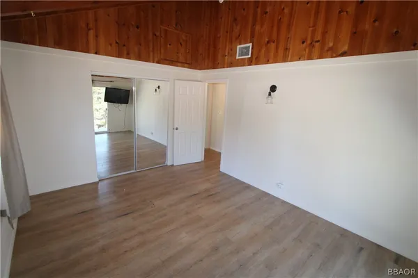 a view of an empty room with wooden floor