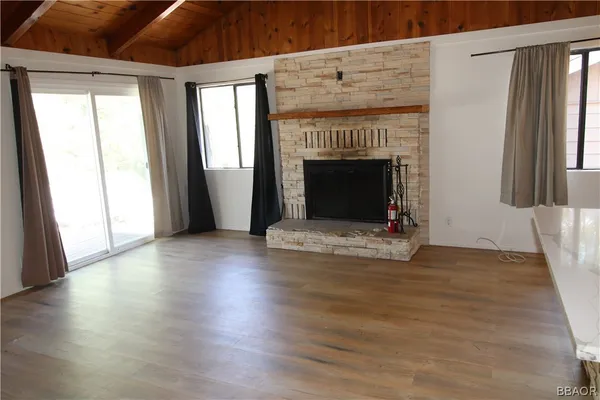 a view of empty room with wooden floor and fireplace