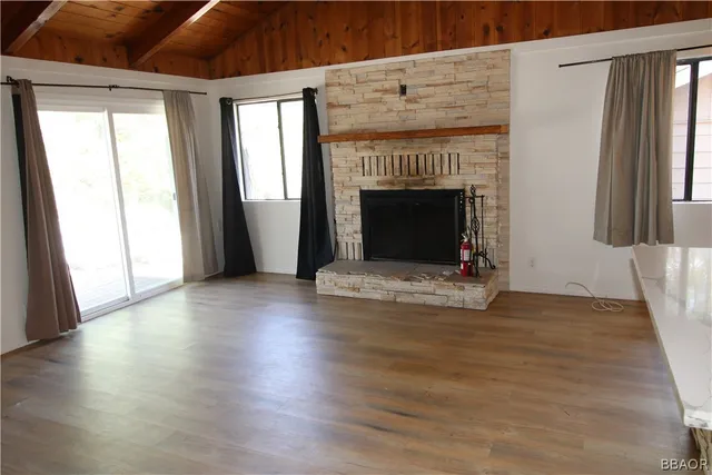 a view of empty room with wooden floor and fireplace