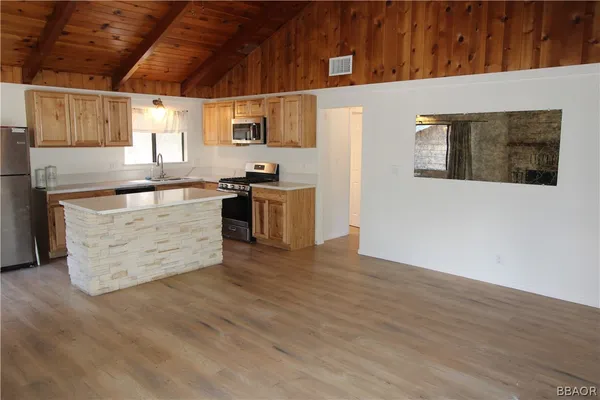 a kitchen with stainless steel appliances granite countertop a stove a sink and a microwave