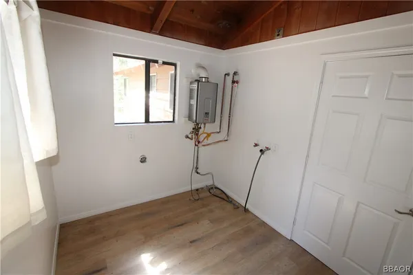 a view of a room with wooden floor and a window