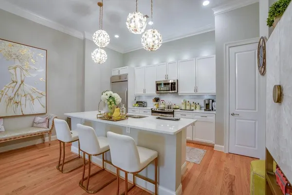 a kitchen with stainless steel appliances a table chairs refrigerator and microwave