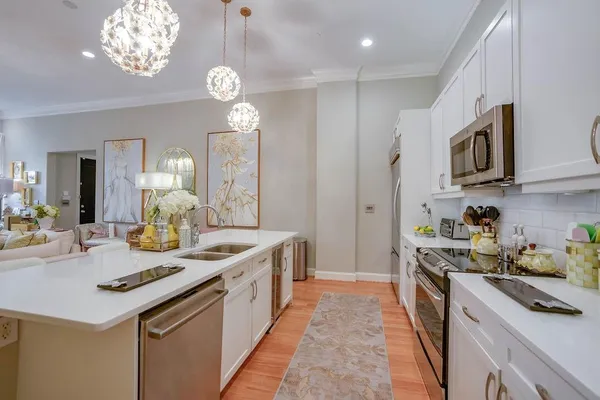 a kitchen with kitchen island granite countertop stainless steel appliances a sink a stove cabinets and a counter top space