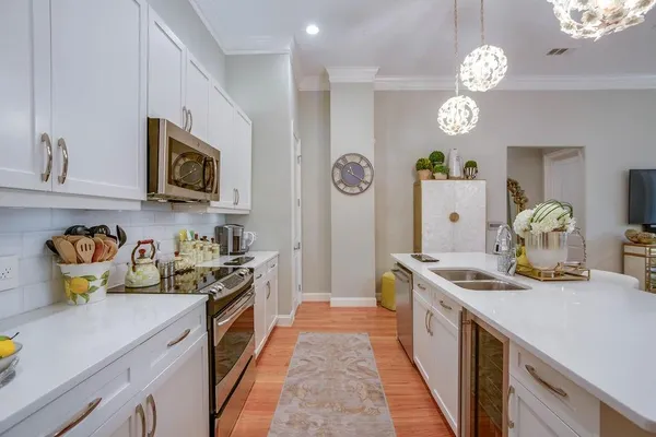 a kitchen with a sink a stove top oven a clock and cabinets