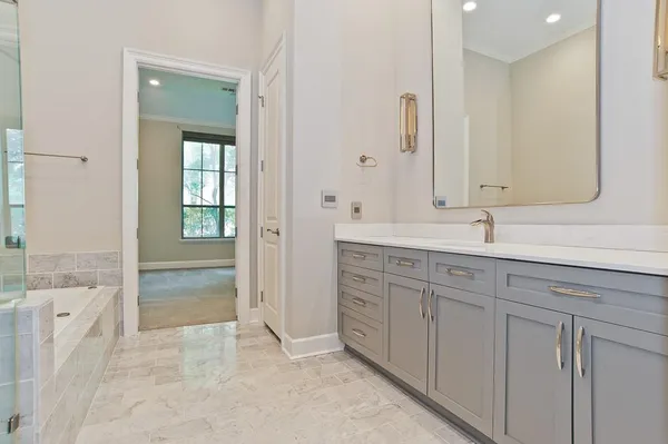 a spacious bathroom with a shower sink and mirror