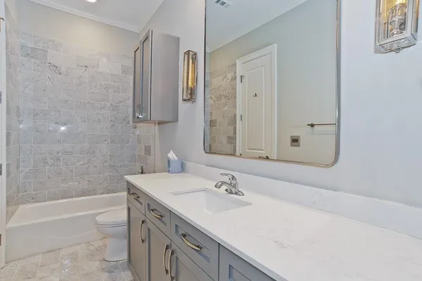 a bathroom with a sink double vanity granite tub shower and a mirror
