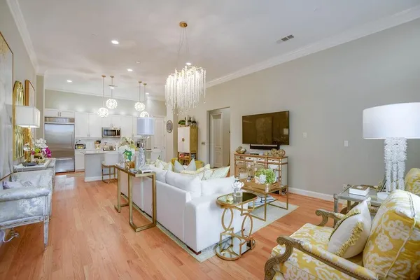 a living room with furniture a flat screen tv and kitchen view