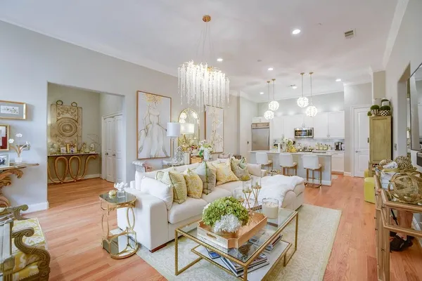 a living room with furniture kitchen view and a chandelier