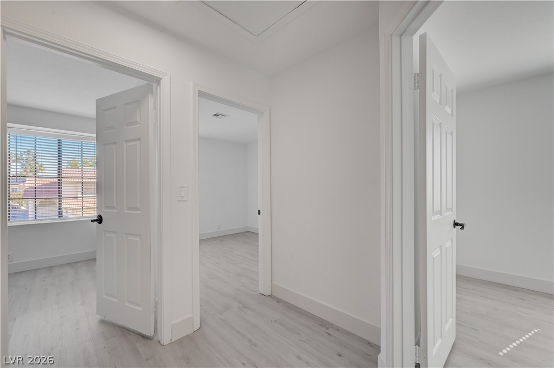 6505 Deadwood Road Las Vegas, NV 89108 - Photo 23 of 33 Clean lines and a light wood floor define this well-lit internal hallway, connecting multiple rooms.