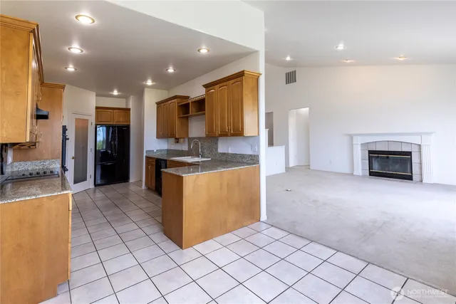 a kitchen with stainless steel appliances kitchen island granite countertop a refrigerator and a stove top oven