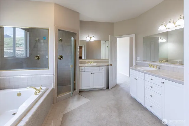 a spacious bathroom with a tub sink shower and mirror