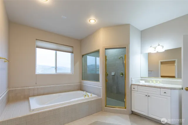 a bathroom with a tub a sink and a mirror